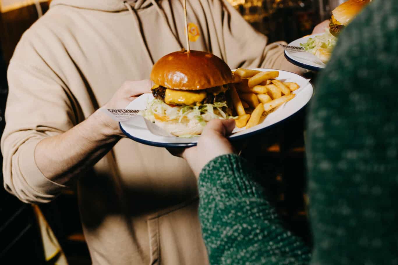 Guests sharing a burger and fries at Alexanderplatz Hostel in Berlin.