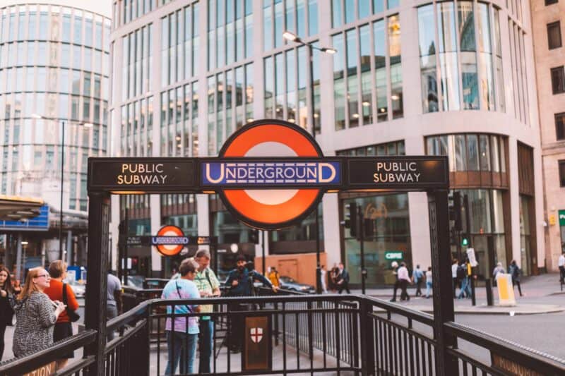 London Underground entrance with busy crowd and iconic signage in the city.