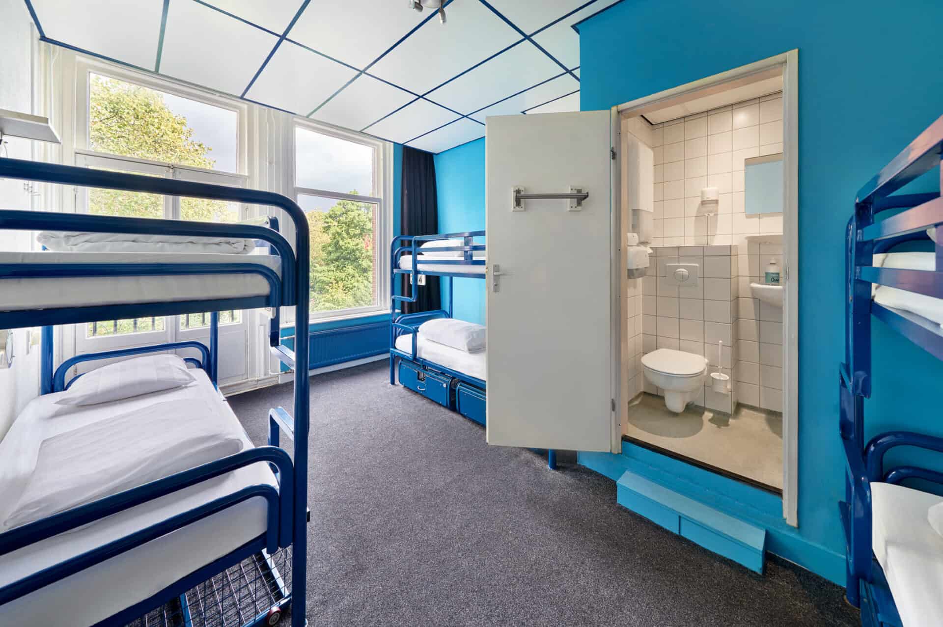 Dormitory room at Flying Pig Uptown Hostel featuring bunk beds and an en-suite bathroom.