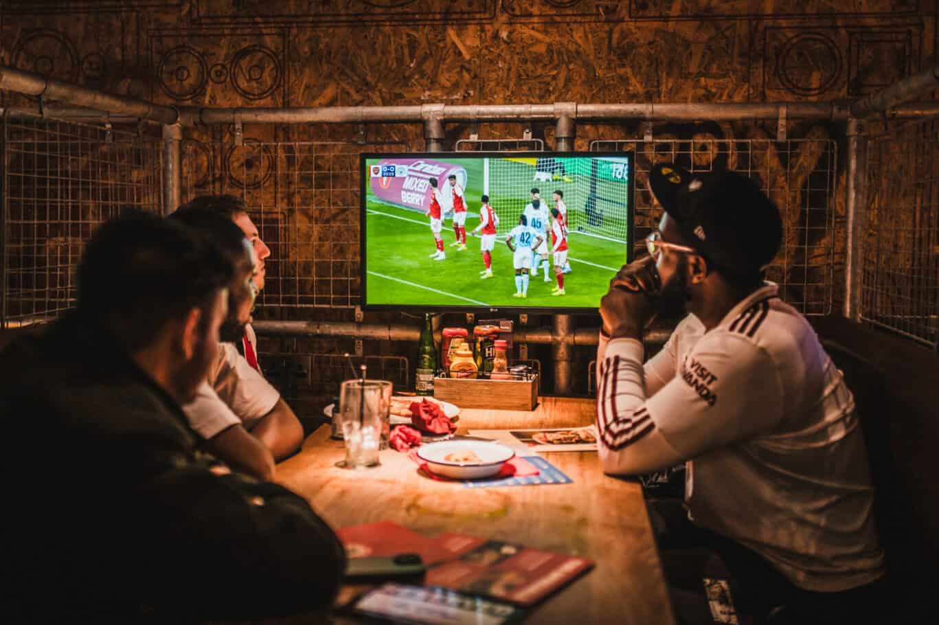 Group of friends watching a football match on TV at Winston Hostel, Amsterdam.