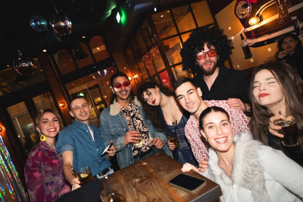 Group of friends enjoying drinks at Winston Hostel Amsterdam bar.