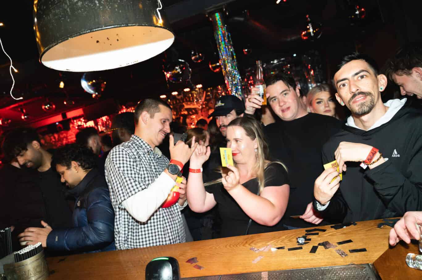 Lively group enjoying drinks and socialising at Winston Hostel bar in Amsterdam.