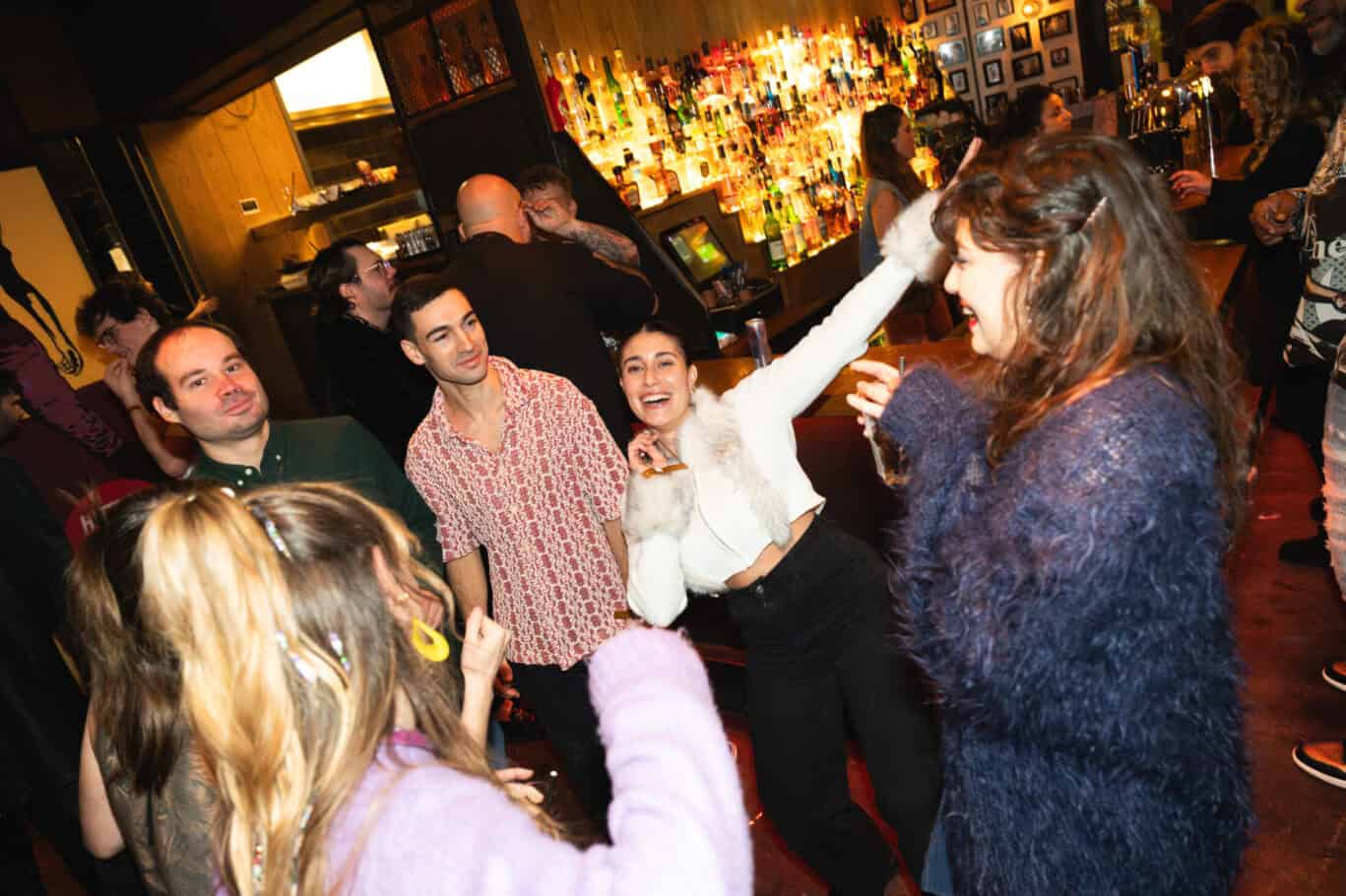 Social night at Winston Hostel in Amsterdam with guests dancing and enjoying drinks.