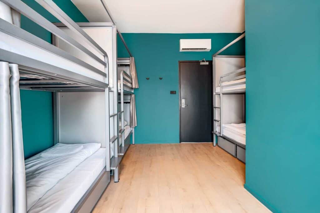 Modern dormitory room at Winston Hostel in Amsterdam with metal bunk beds and colourful walls.