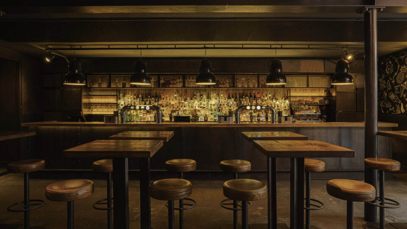 Cozy bar at St Christopher’s Amsterdam - The Winston, featuring warm lighting and a welcoming atmosp.