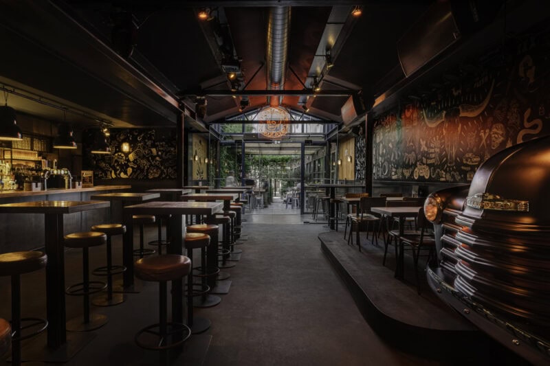 Brightly lit, modern bar with colourful murals and seating area.