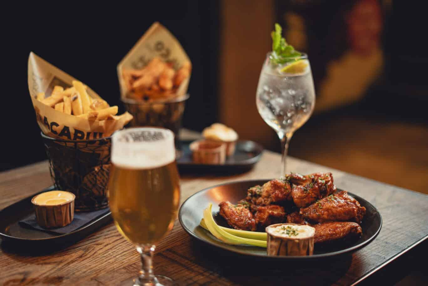 Delicious chicken wings, beer, and cocktails served at Winston Hostel in Amsterdam. Perfect for soci.
