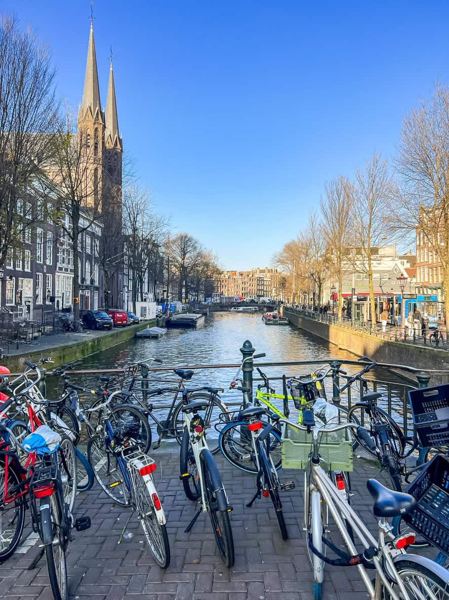 View of the canal in Amsterdam with bicycles and historic buildings.