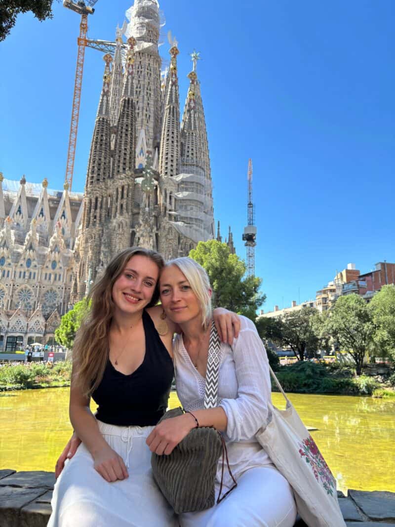 Sagrada Família in Barcelona with two women smiling in front of the iconic basilica.