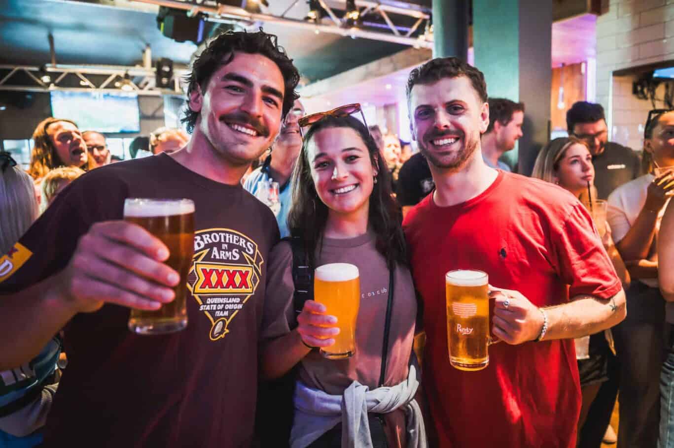 People having fun with beers at a lively hostel bar in Barcelona.