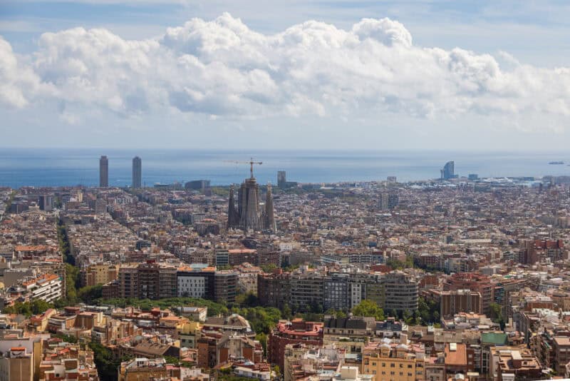 City view of Barcelona featuring the Sagrada Família and the coastline in the background.
