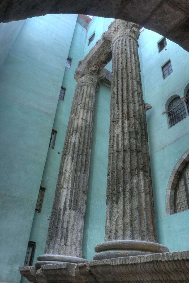 Historic Roman-style columns inside St Christopher’s Hostel in Barcelona, showcasing ancient archite.