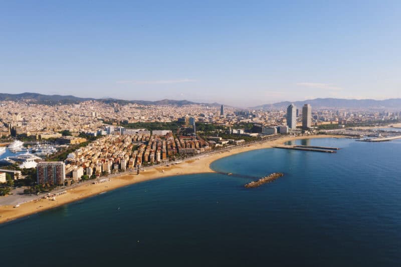 Aerial view of Barcelona's coastline with sandy beaches and urban skyline, showcasing the vibrant ci.