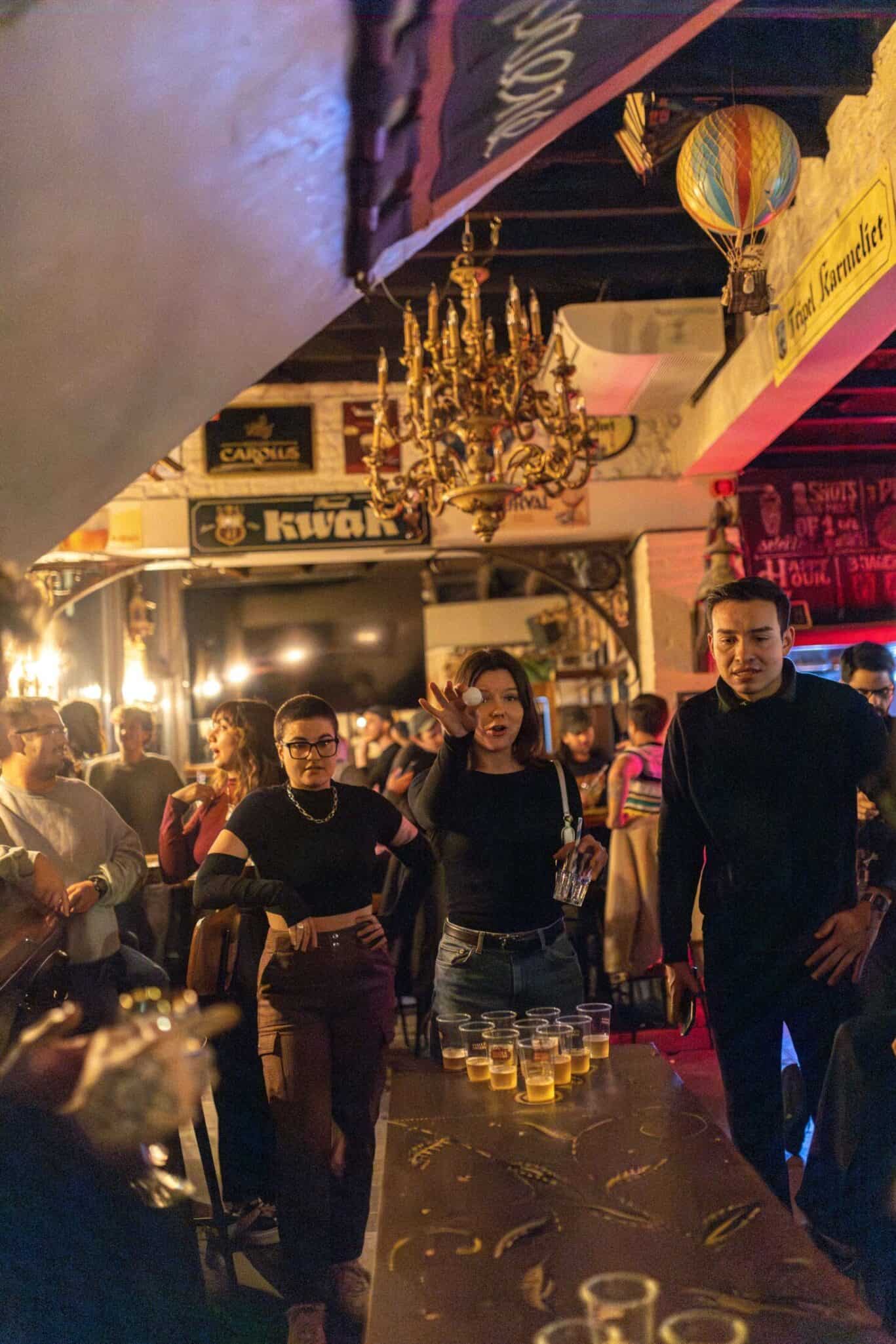Group of people enjoying drinks at a lively bar in St Christopher’s Bruges, The Bauhaus.