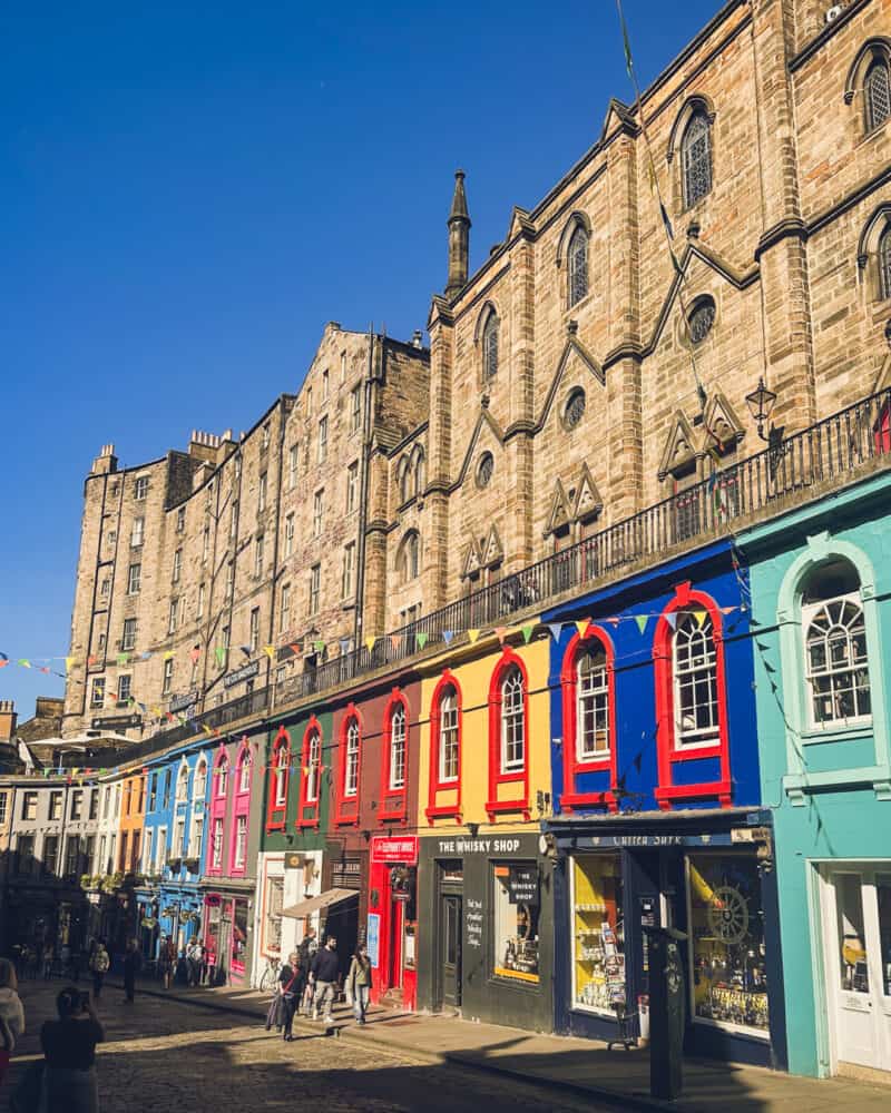 Colourful row of shops and bars in a lively street scene.