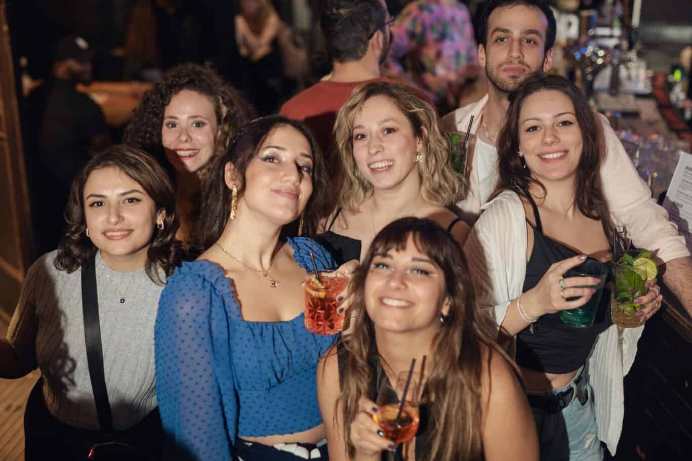 Group of friends enjoying drinks at a lively bar in Berlin.