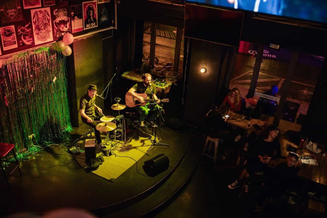 Live band playing acoustic music on stage at St Christopher’s Berlin hostel.