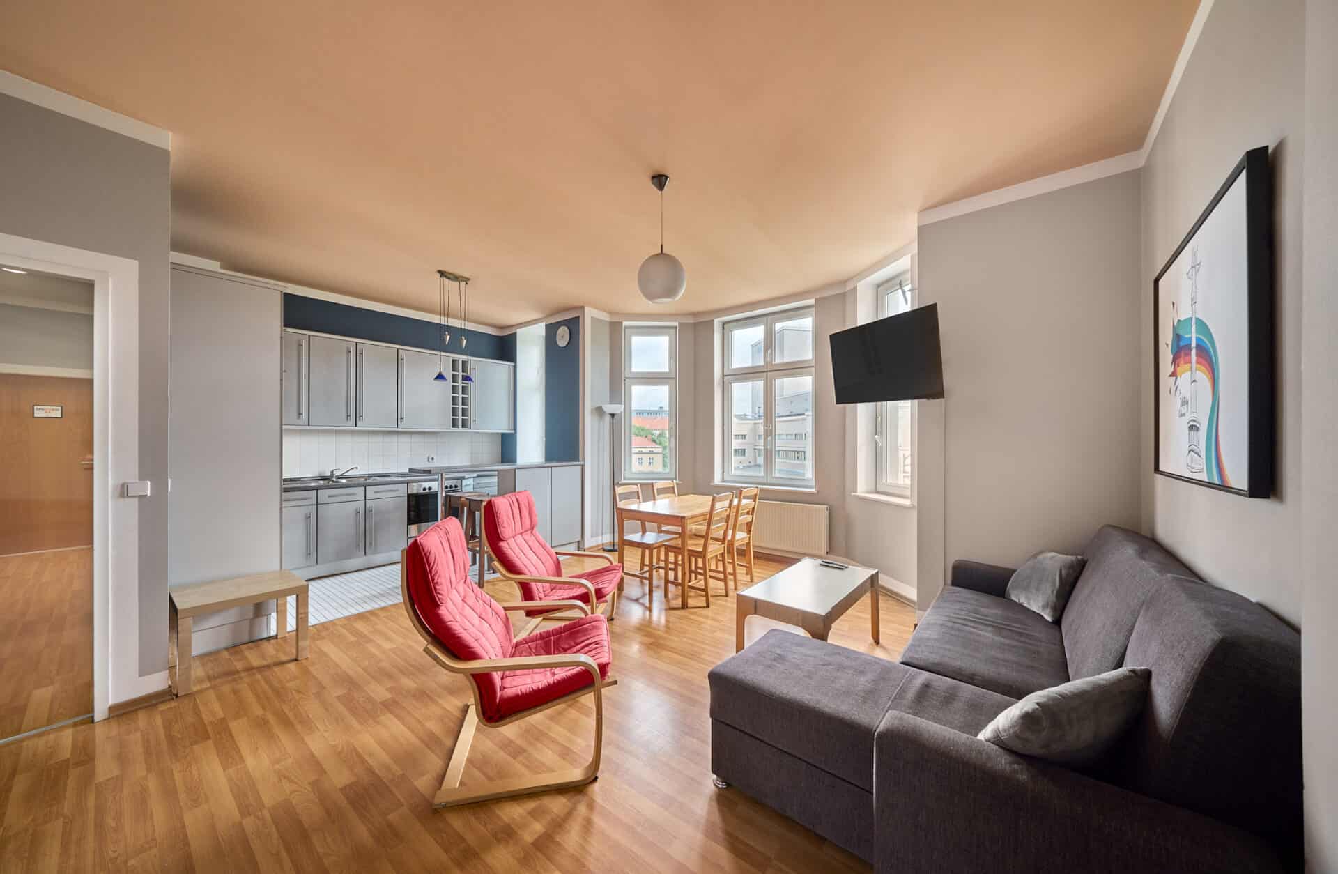 Bright and spacious living area with large windows, comfortable seating, and a flat-screen TV.