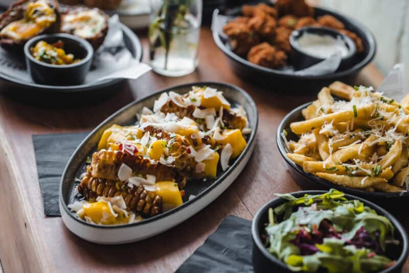 A variety of pasta and salad dishes served in bowls and plates on a wooden table.