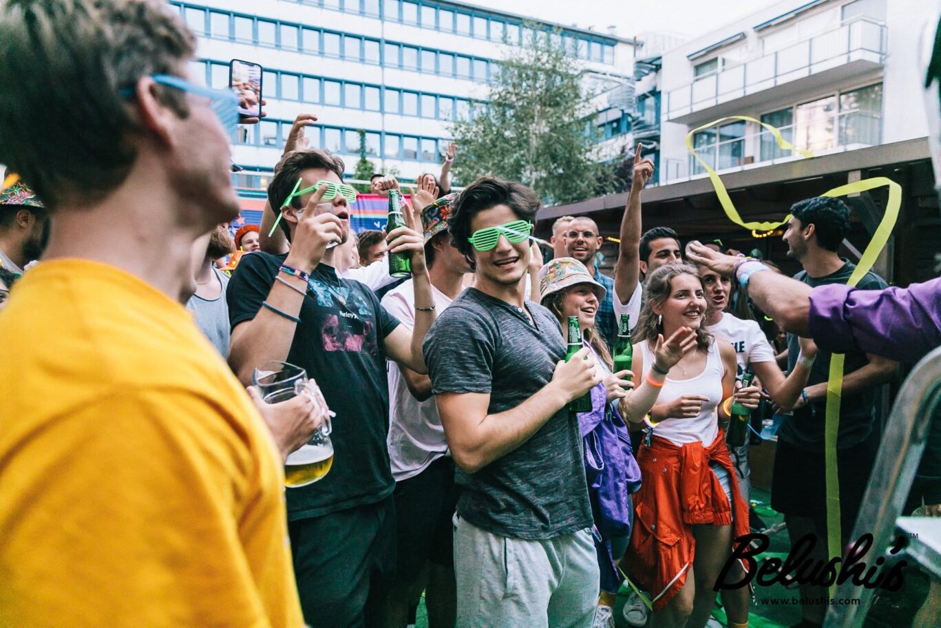 Vibrant hostel party scene at St Christopher's Berlin Mitte with young travellers enjoying drinks.