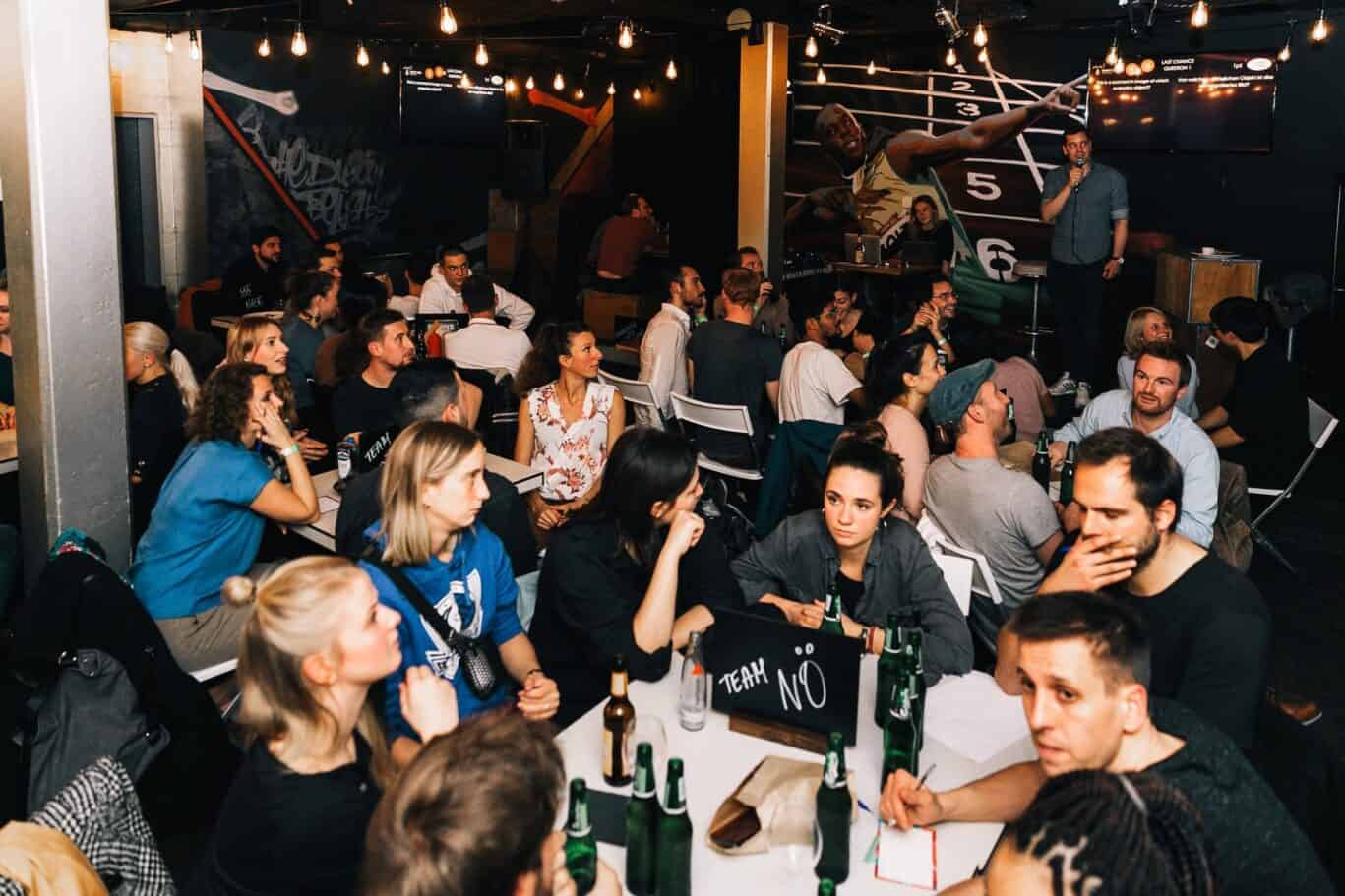 Social scene at St Christopher's Berlin Mitte with travellers enjoying drinks and live music.
