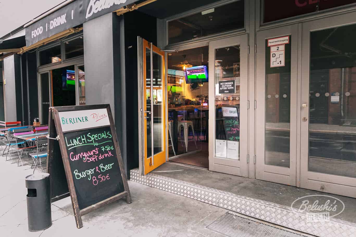 Entrance of St Christopher’s Berlin hostel in Mitte, with outdoor seating and a chalkboard menu.
