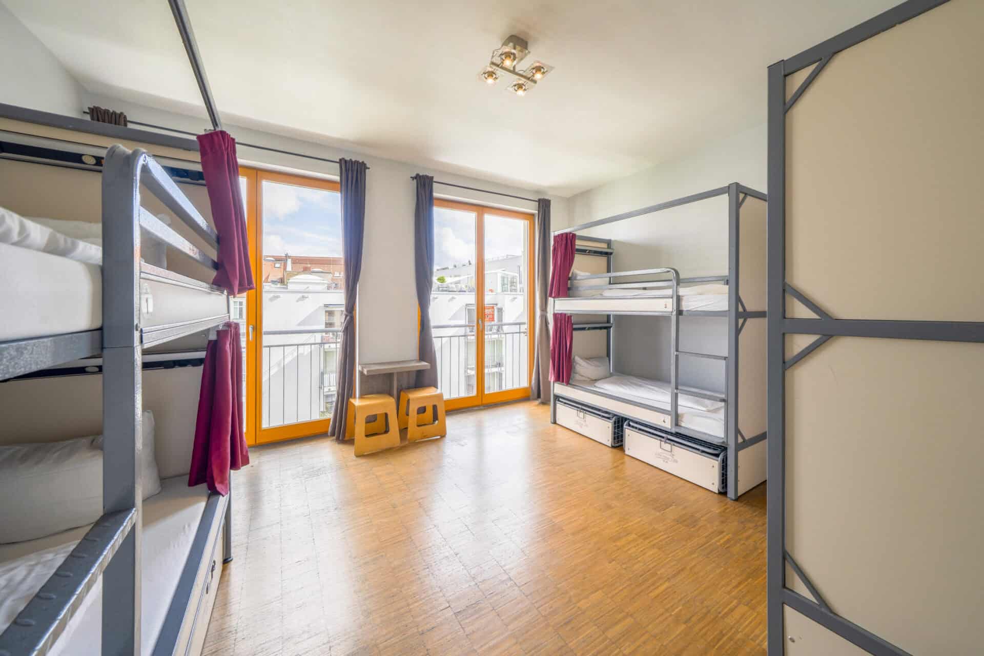 Bright dorm room with bunk beds and large windows in Mitte, Berlin.