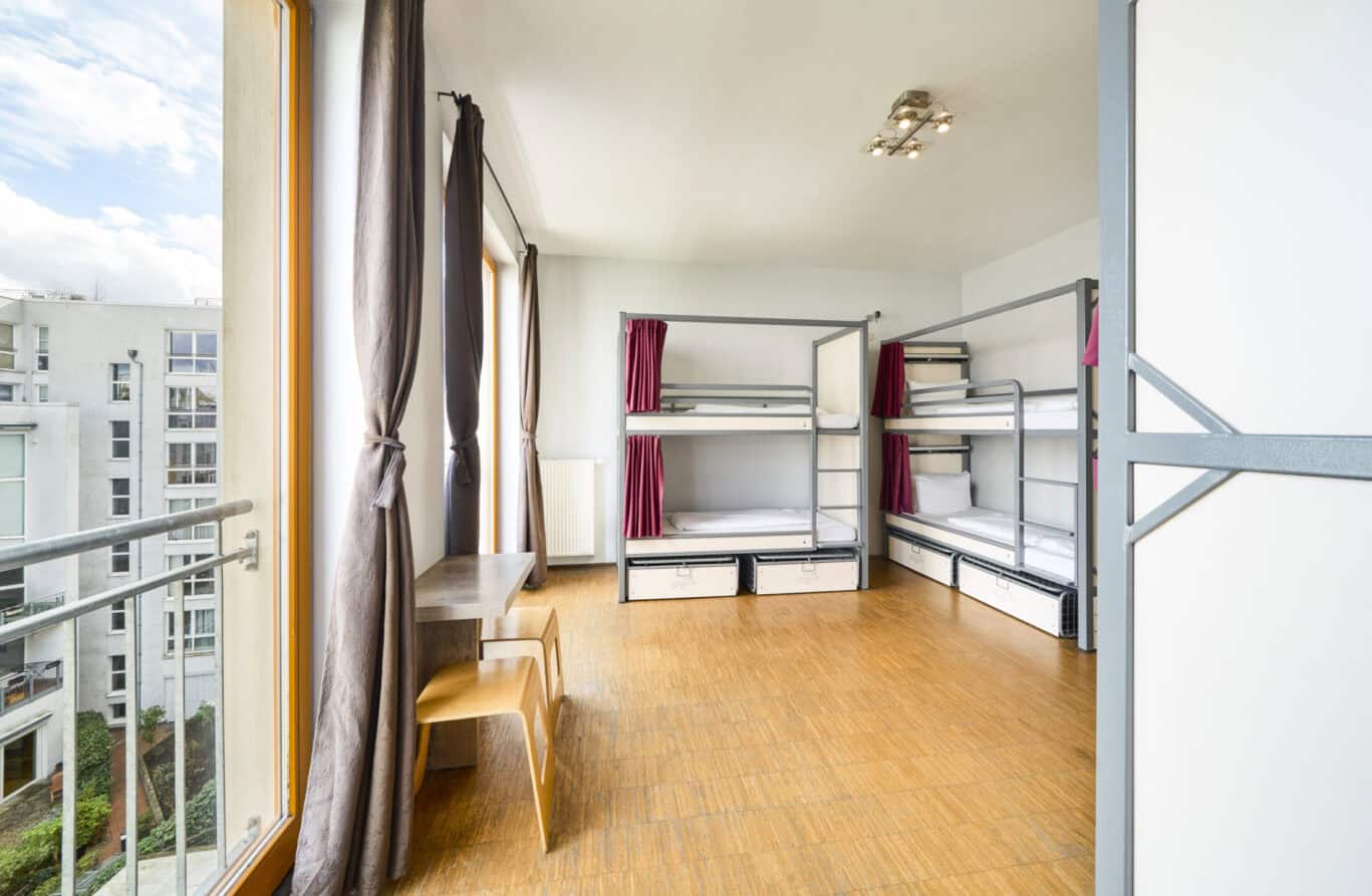 Bright hostel dorm with bunk beds and large windows in Berlin Mitte.
