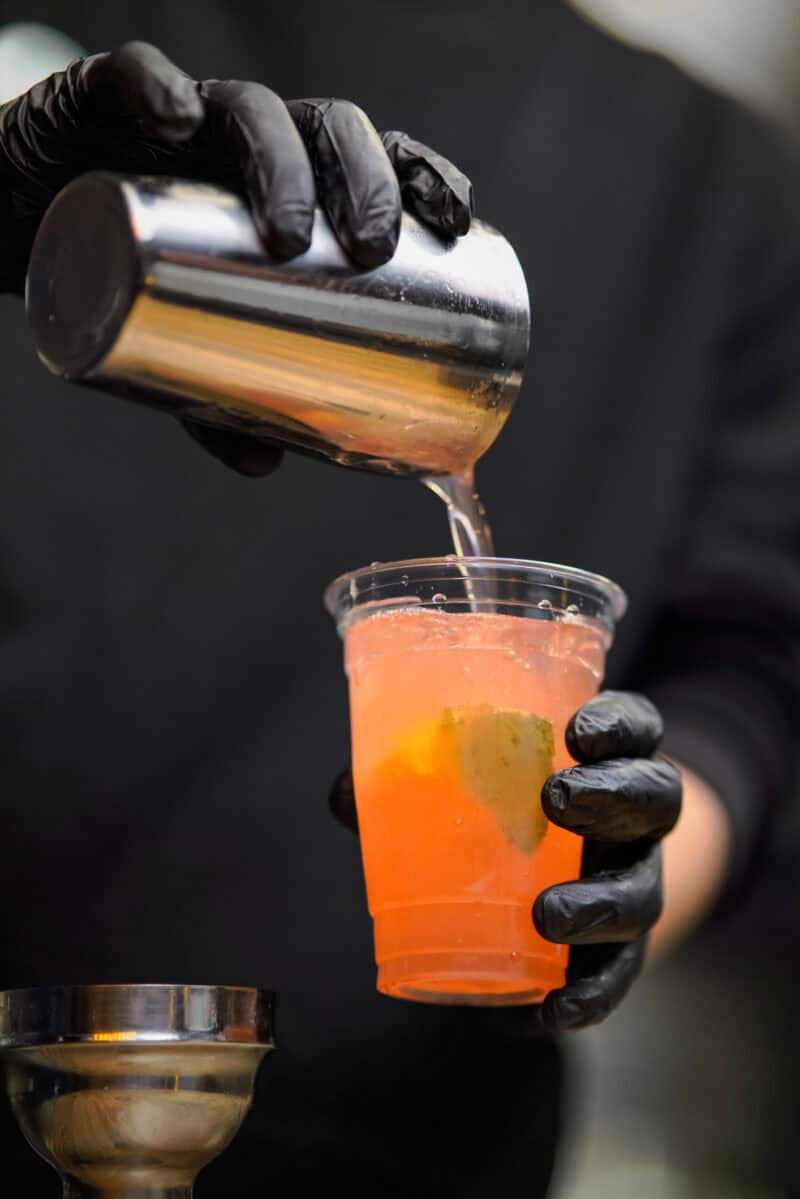 A bartender pouring a cocktail at St Christopher's Berlin - Mitte hostel bar.