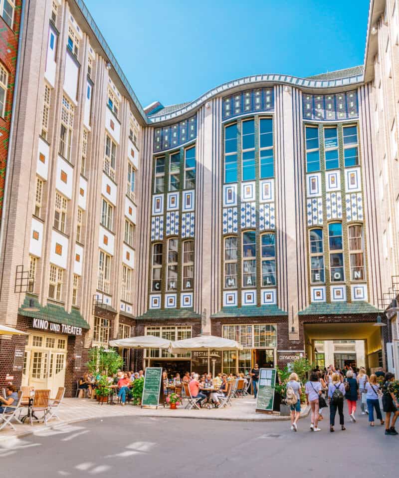 Modern Mitte Hostel building with outdoor seating and visitors in Berlin.