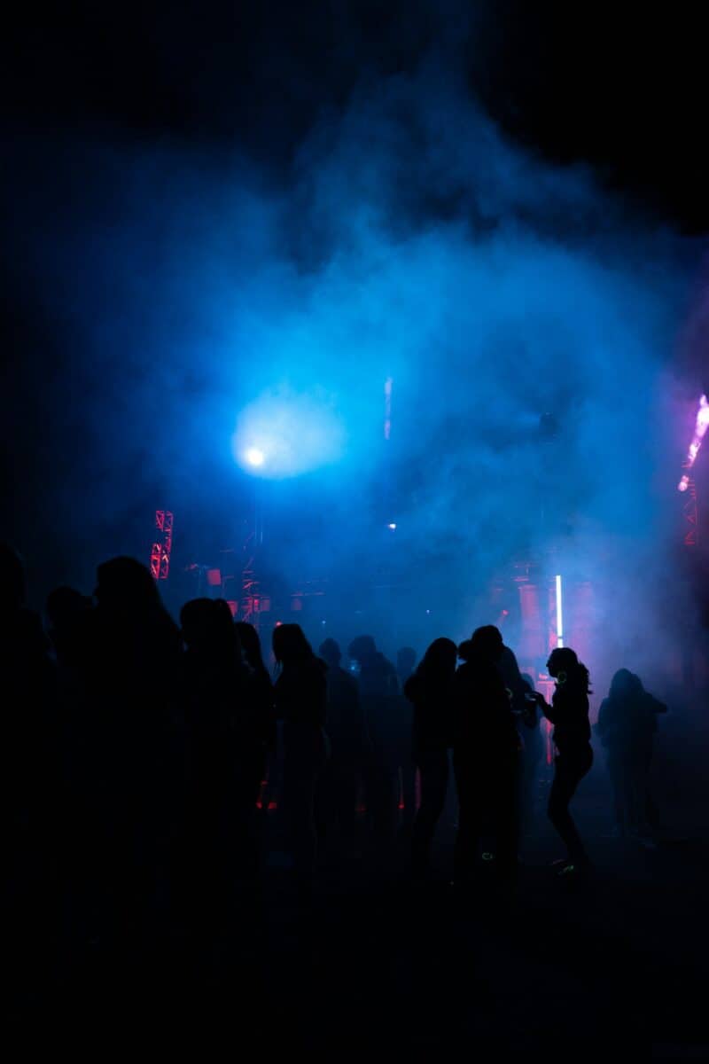 Nightlife scene at St Christopher's Berlin Mitte with silhouettes of people and colourful lights.