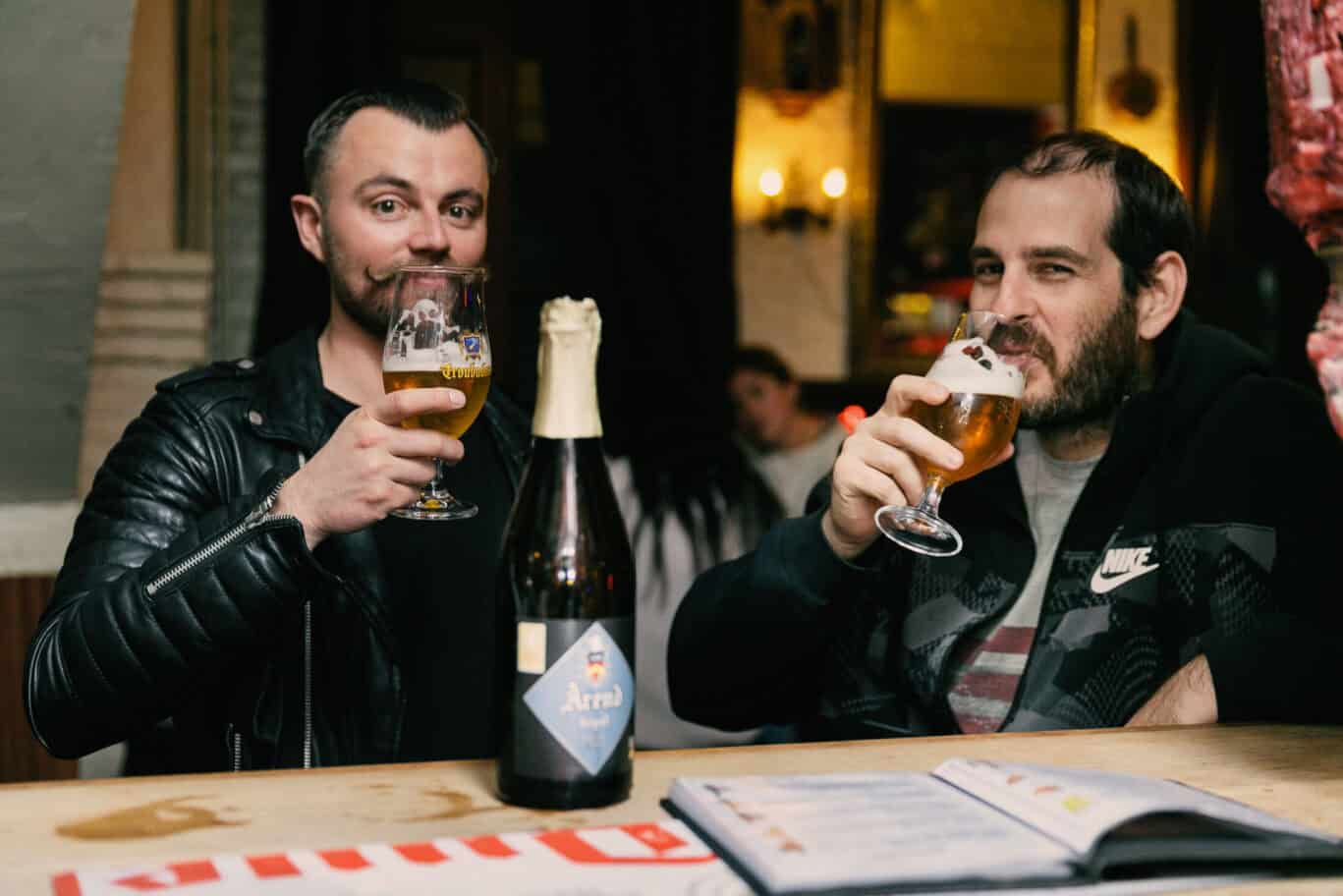 Two men enjoying beers at St Christopher’s Bruges, The Bauhaus hostel.