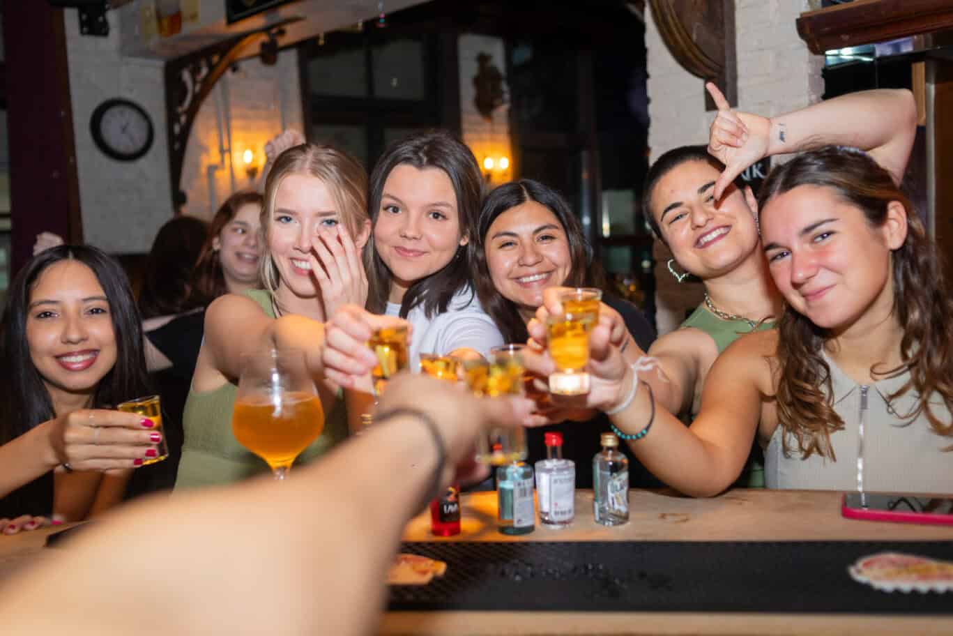Group of young friends enjoying drinks together at a lively bar.