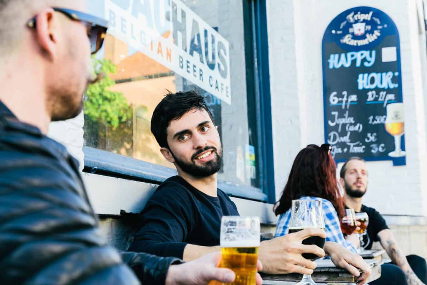 Group of friends enjoying drinks outside Bauhaus Hostel in Bruges, Belgium.