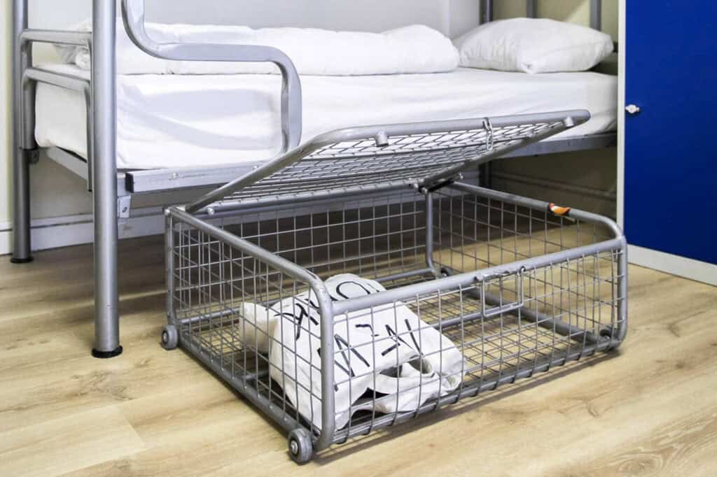 Bunk bed with a metal storage basket beneath, located in a hostel room at St Christopher’s Bruges -.