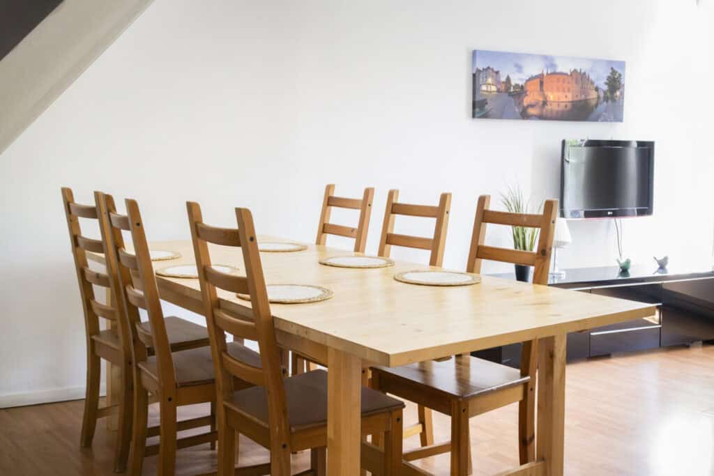 Spacious dining room with wooden table and six chairs, bright and welcoming interior at St Christoph.