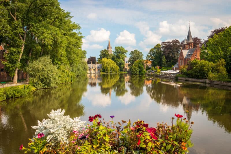 Beautiful view of Bruges river with historic buildings and lush greenery, showcasing the Bauhaus Hos.