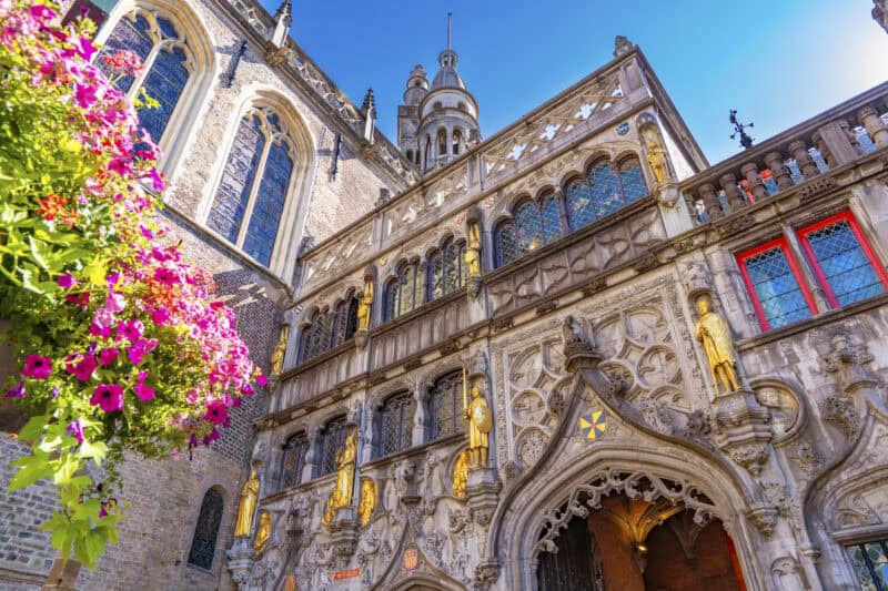Historic Gothic architecture of St Christopher’s Bruges with ornate details and golden statues.