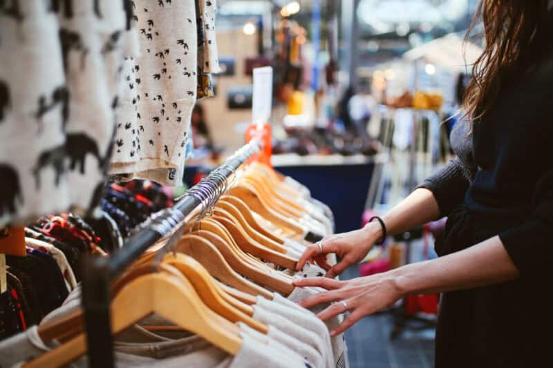 Woman shopping for clothes at an outdoor market in Berlin, showcasing fashion and shopping experienc.