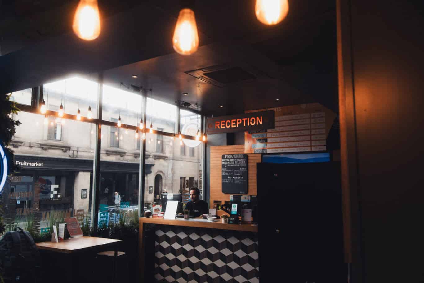 Reception area of St Christopher’s Edinburgh hostel with warm lighting and modern decor.