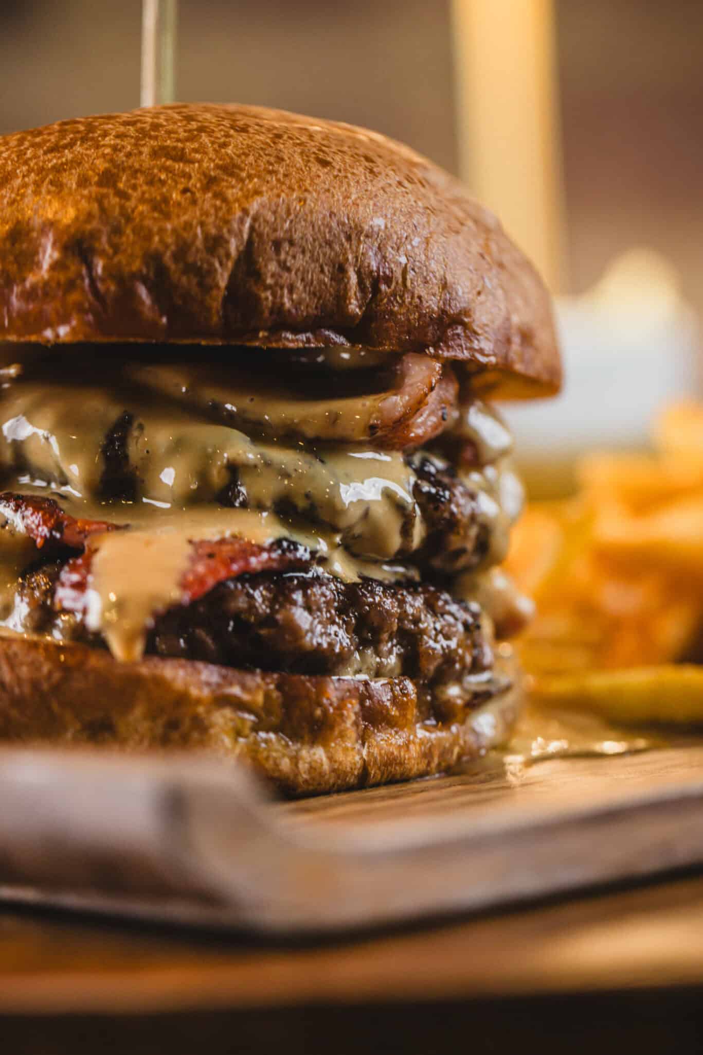 Delicious cheeseburger with melted cheese, crispy bacon, and fresh ingredients served at Gare du Nor.