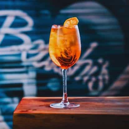 An inviting cocktail garnished with an orange slice on a wooden table.