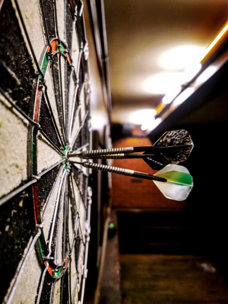 Darts hitting the bullseye on a dartboard at Gare du Nord hostel in Paris.