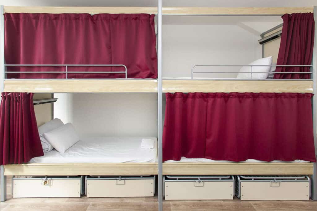 Bunk beds with red curtains for privacy at St Christopher’s Paris - Gare du Nord.