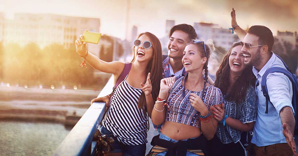 Group of friends taking a selfie on a bridge