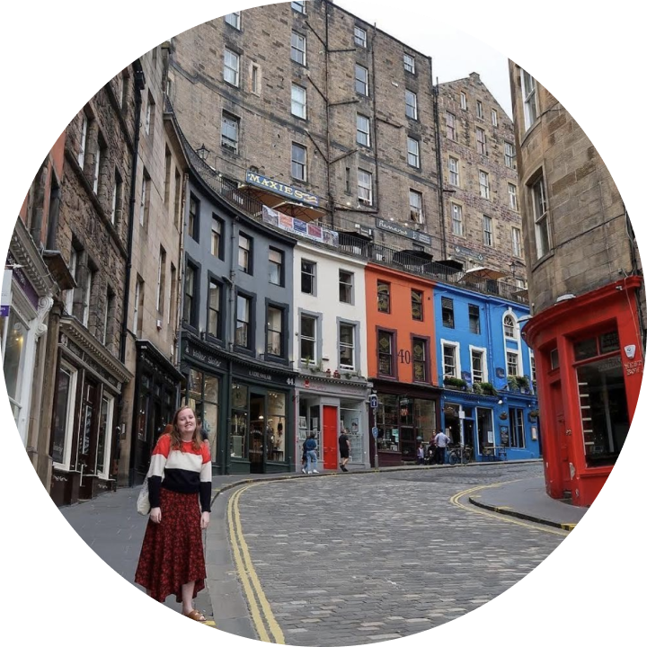 A young woman stands on a city street on a hill