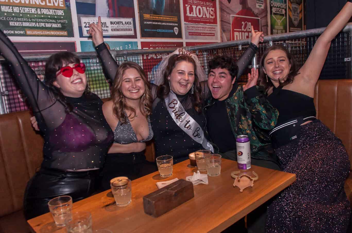 Group of friends celebrating at Las Ramblas Hostel in Barcelona, enjoying drinks and fun.