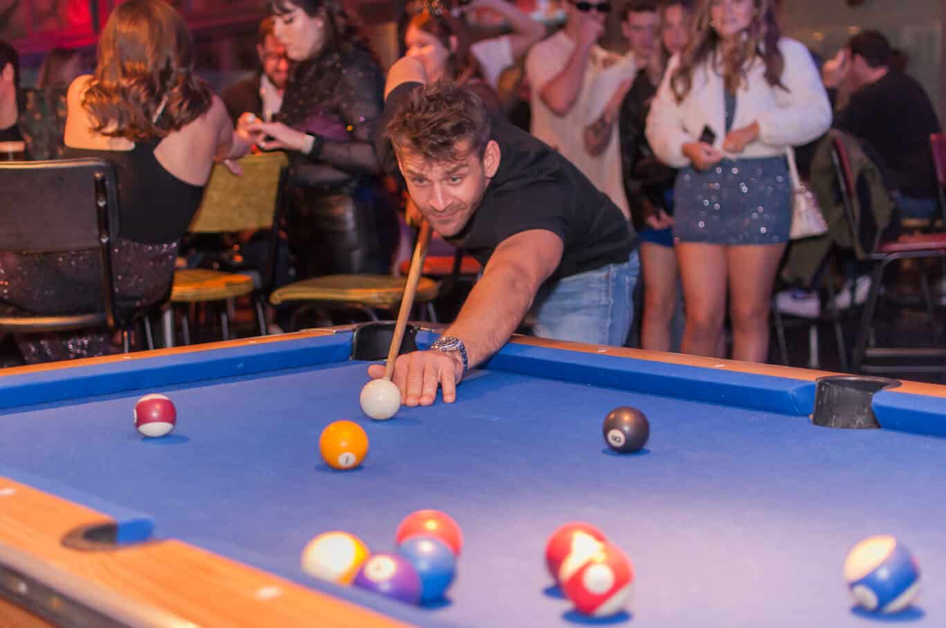 Pool game with players enjoying a lively atmosphere at St Christopher’s Barcelona hostel.
