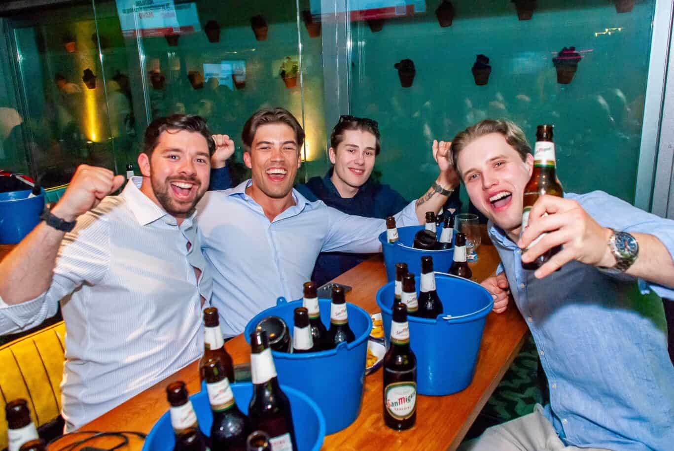 Group of friends having fun with drinks at St Christopher’s Barcelona hostel.