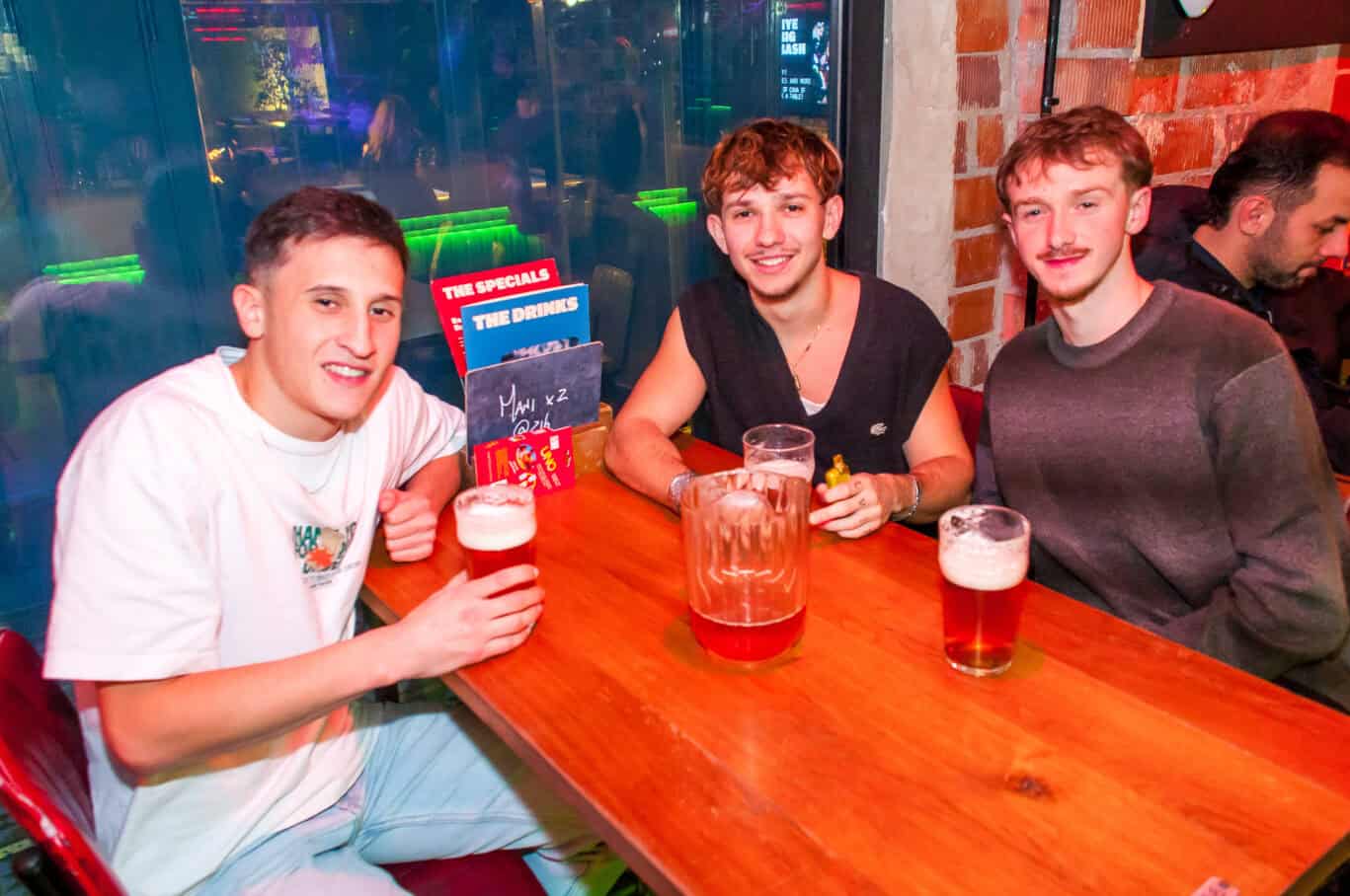 Young people enjoying drinks at a lively bar in St Christopher’s Barcelona hostel.